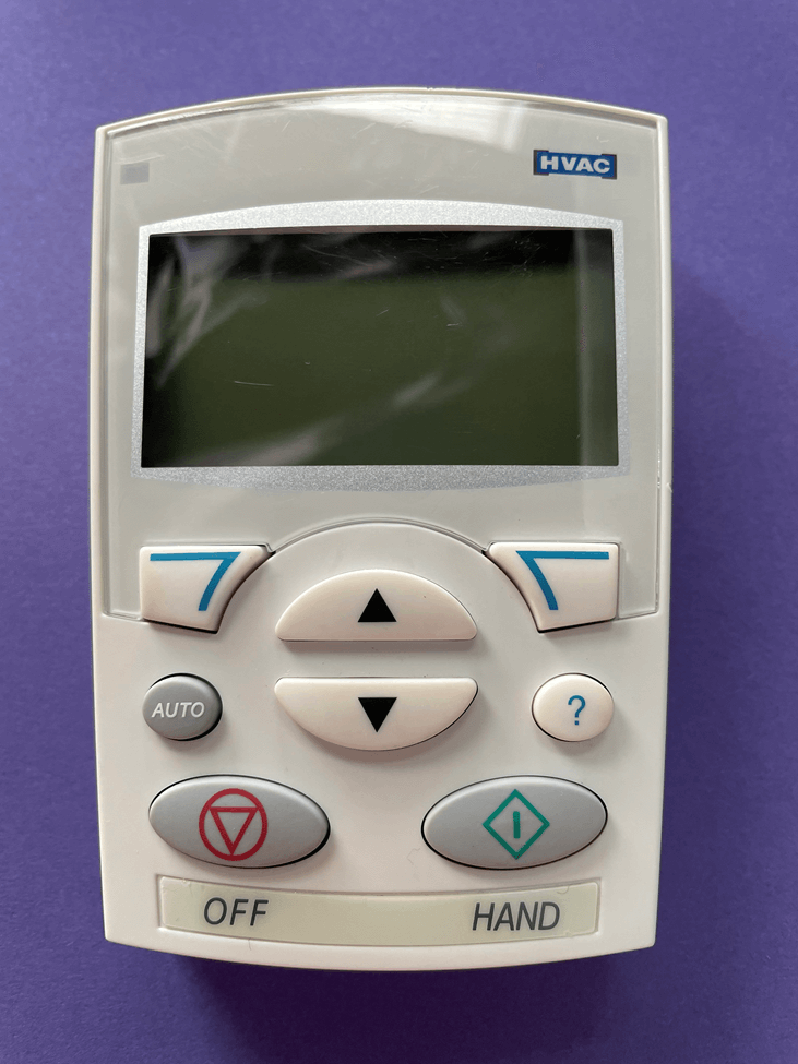 Control panel with a blank screen, arrow buttons, and red and green function keys on a beige device.