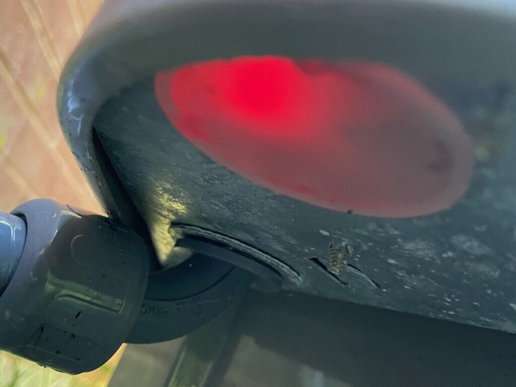 Close-up of a black device with a glowing red light on a wooden surface