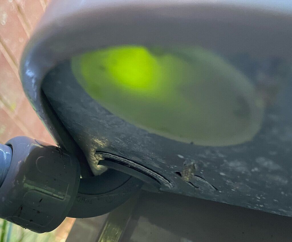 Close-up of a gray stroller wheel with a bright green reflective spot on the seat