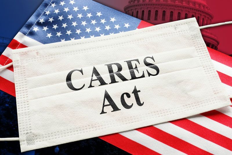 Face mask labeled “CARES Act” over a U.S. flag background