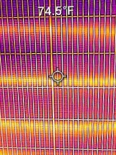 Thermal view of a striped surface with orange, pink, and yellow bands and a circular center marker.