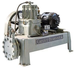 Vintage industrial refrigeration compressor unit with motor and metal pipes, labeled Carrier-Bruuswick.