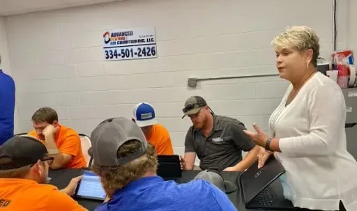Woman speaking to seated workers in a classroom or training room