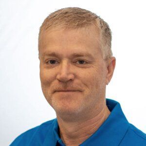 Portrait of a man in a blue polo shirt against a light background