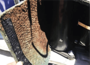 Close-up of a brown textured bag beside a glossy black suitcase or cabinet.
