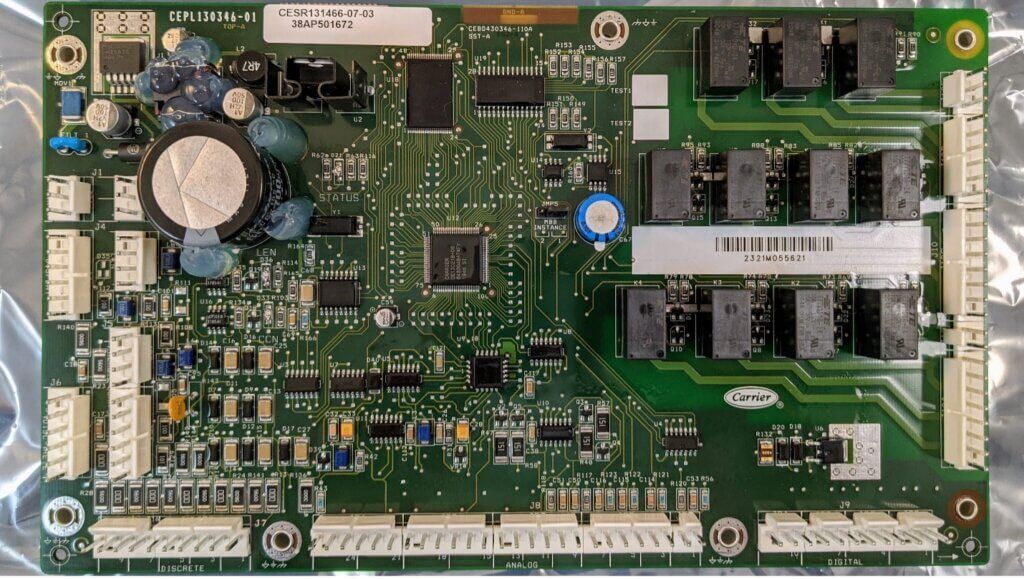 Green computer circuit board with chips, connectors, capacitors, and white expansion slots.