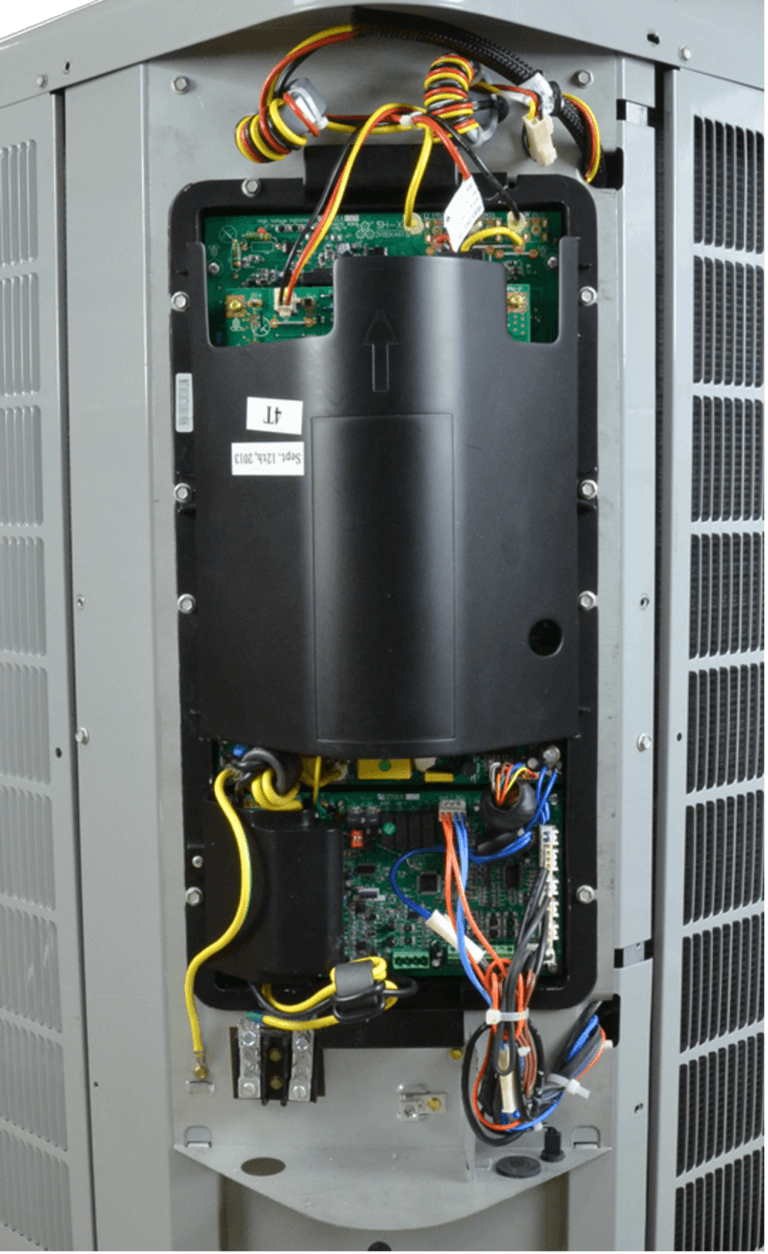 Interior of an electrical cabinet with exposed wiring, circuit boards, and a large black component.