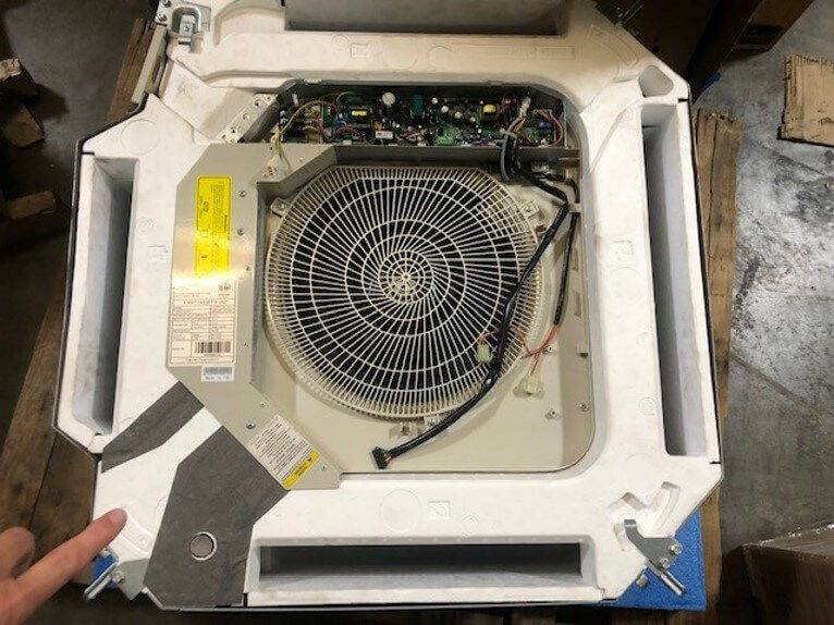 Top view of an open industrial machine with a large circular fan and exposed wiring inside a white housing