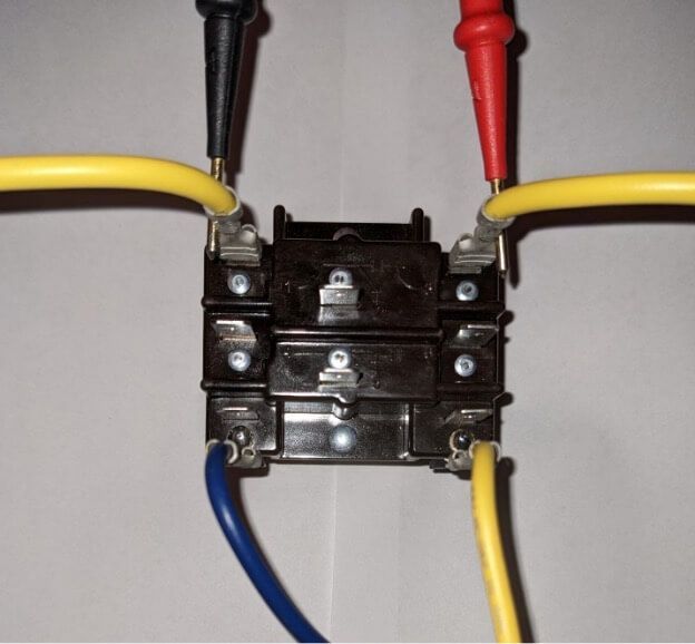 Close-up of a black electrical terminal block with red, black, blue, and yellow wires connected