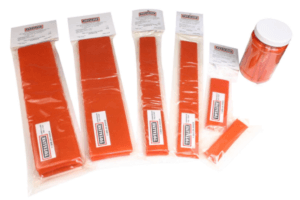 Orange safety flagging tape rolls and packs arranged on a white background