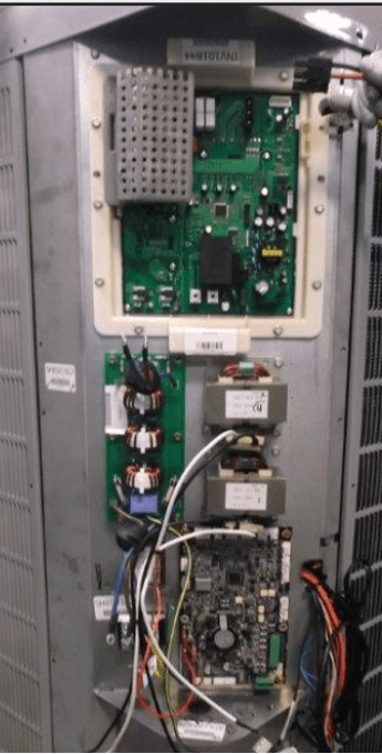 Open electronic control panel with circuit boards, wiring, and components inside a metal enclosure