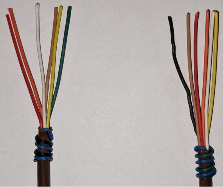 Two bundled cables with exposed multicolored wires on a white background