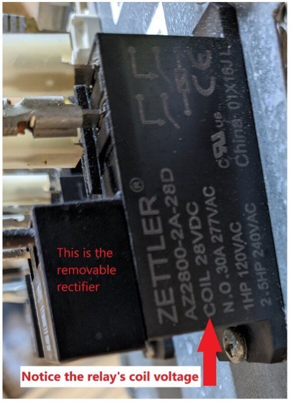 Close-up of a black Zettler relay with red annotations pointing to the removable rectifier and coil voltage.