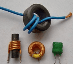 Three small electronic inductors and a ferrite bead on a blue wire, shown on a white background