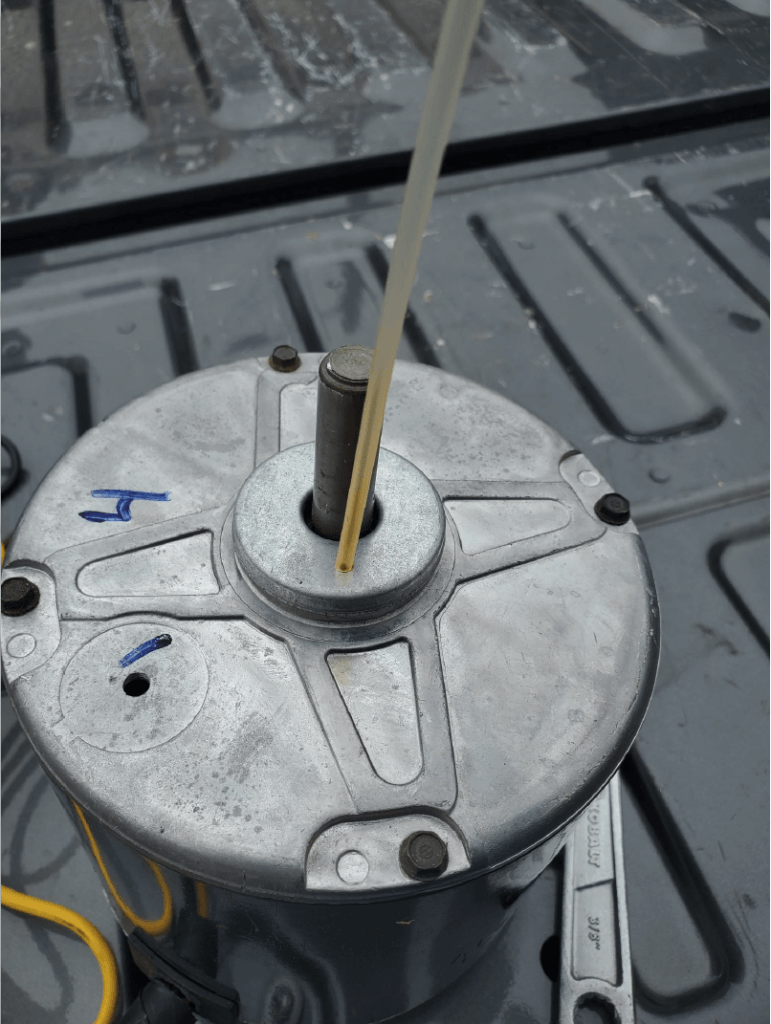 Close-up of a metal circular part with wires and a central shaft on a truck bed surface