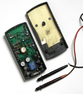 Open electronic device with circuit board, battery, and two detached pen-shaped probes on a white background