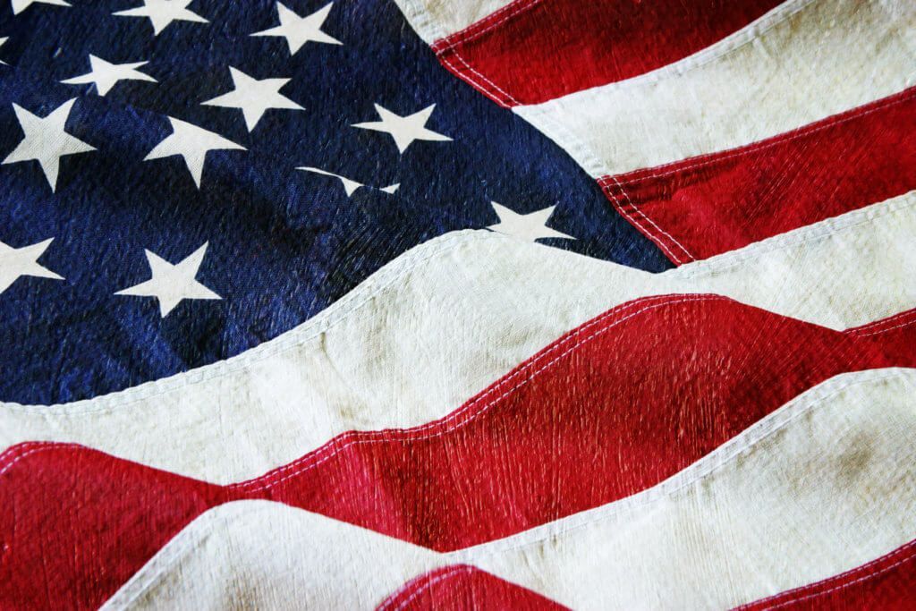 Waving American flag with red and white stripes and a blue field of white stars