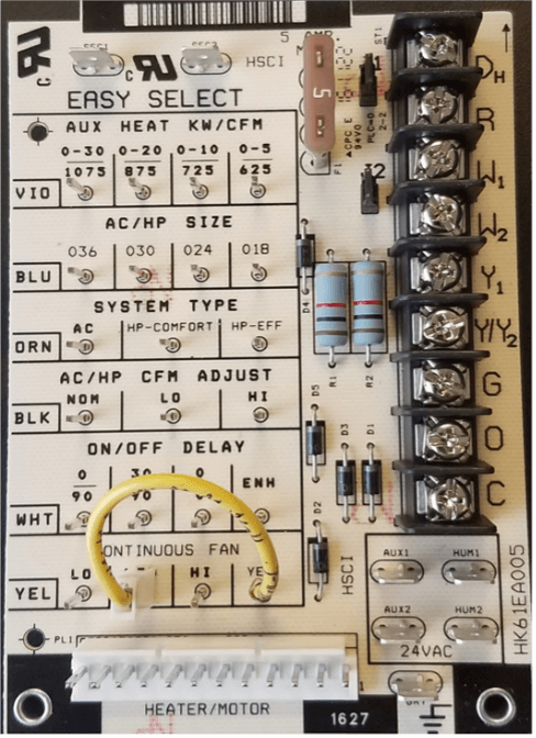 HVAC control board with labeled dip switches, wiring terminals, and adjustment dials inside an electrical panel