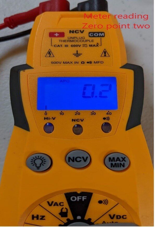 Yellow digital multimeter showing 0.2 on blue backlit screen, with warning text at top.
