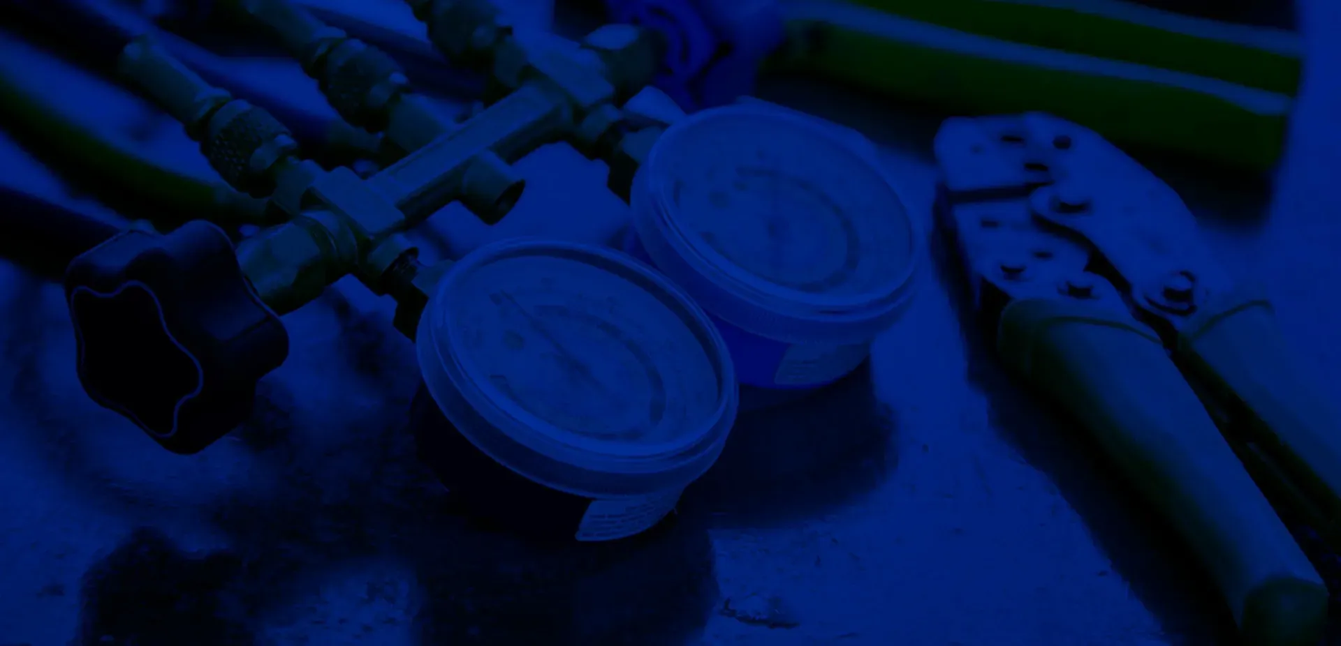Blue-toned scuba diving gear with a regulator, gauges, and fins on a table