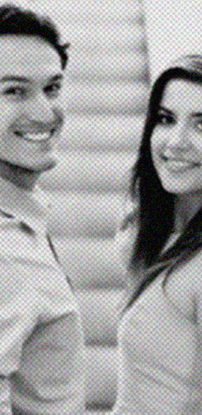 Un hombre y una mujer están parados uno al lado del otro y sonriendo en una foto en blanco y negro.