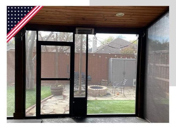 Screened porch with dark trim, door, and view of a backyard with patio furniture and fire pit.