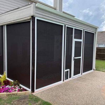 Screened-in porch with white frames and black screens; a door and a pet door are visible.