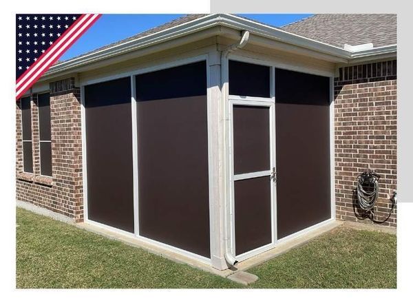 Brown-screened patio enclosure with white trim on a brick house. Includes a screen door, and the American flag.