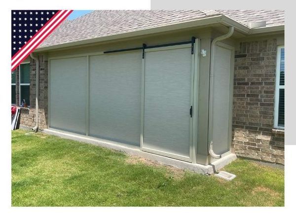 Sliding panel shades on a patio, with an American flag icon in the corner.
