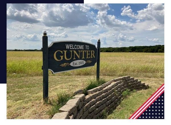 Sign welcoming visitors to Gunter, Texas, established 1900, with a field in the background and a cloudy sky.