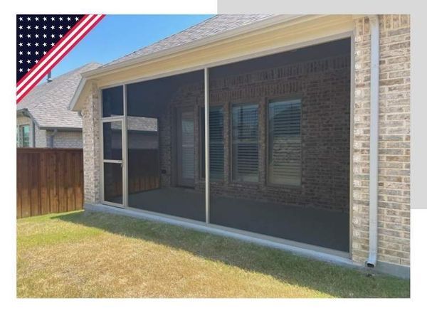 Screened-in porch on a brick house; includes a gray concrete floor, and a grassy yard.