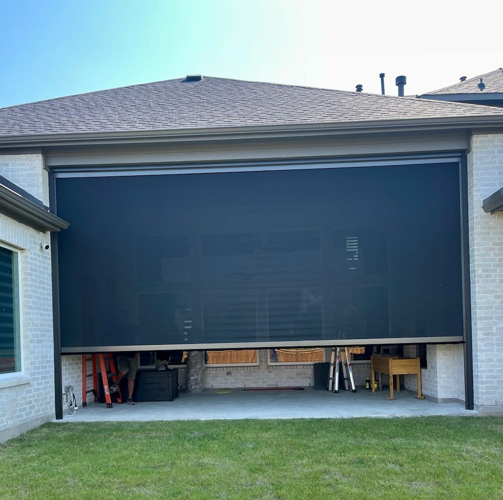 Large black retractable screen partially covers an outdoor patio.