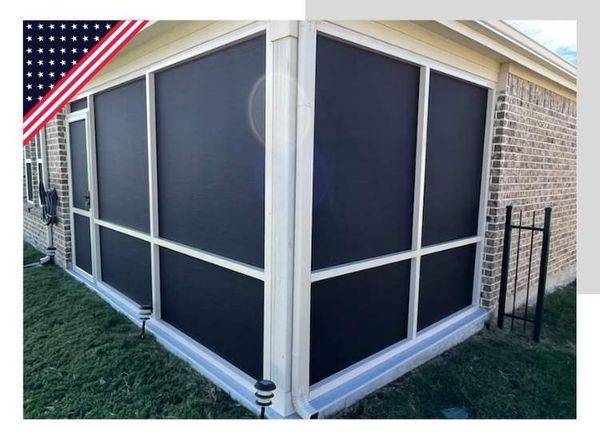 Screened-in porch with black screens, white framing, and brick exterior. American flag graphic in corner.