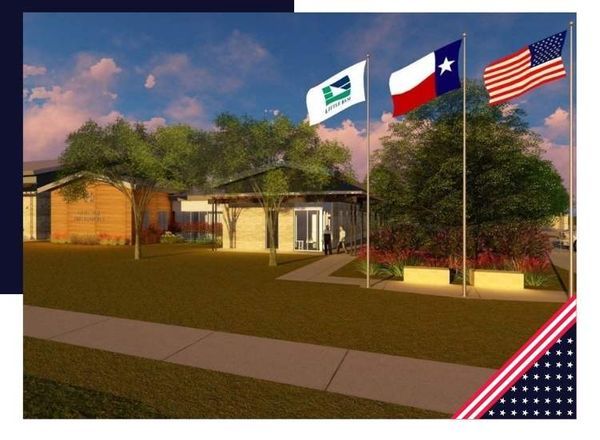 Building with flags; green logo, Texas, and US flags.