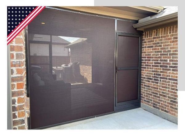 Screened-in porch with brown screen walls, door, brick exterior, and a glimpse of a courtyard.
