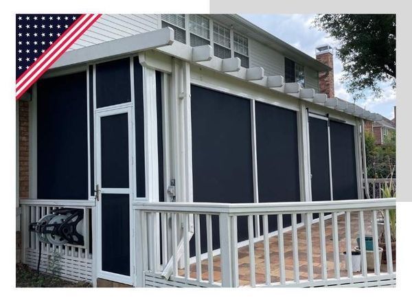 Screened porch with dark screens, white frame, and a deck with a white railing. American flag on the upper left.