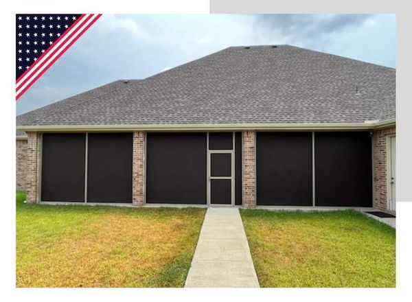 Screened-in patio with brick columns and dark screens, a concrete path, and a gray roof.
