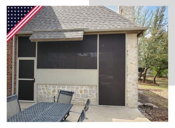 Outdoor screened patio with stone facade and table set.