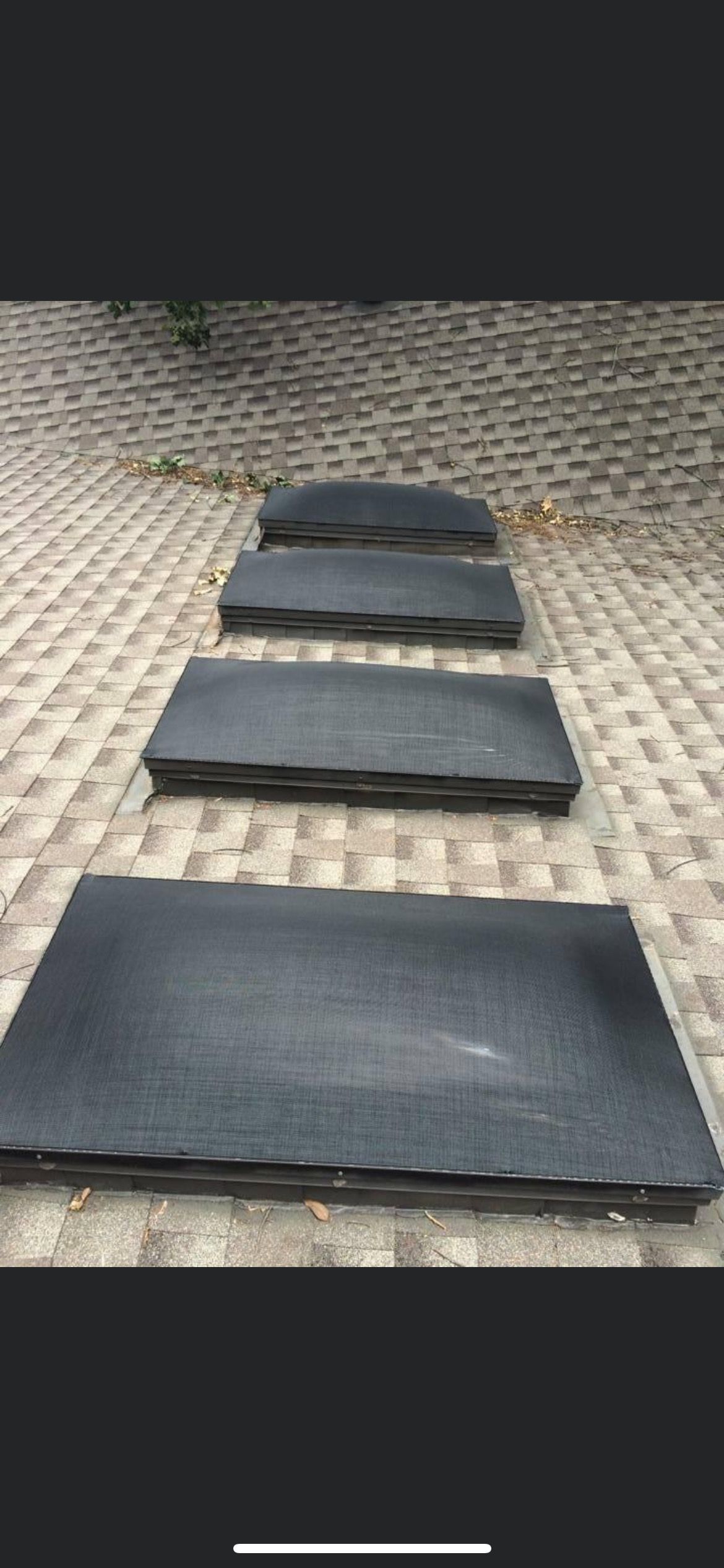 Four dark rectangular stepping stones are laid out on a stone patio, leading toward the background.
