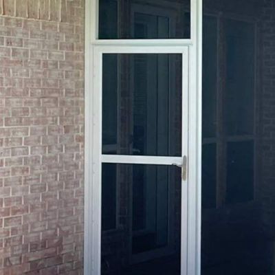 White screen door with an attached upper window on a brick wall.
