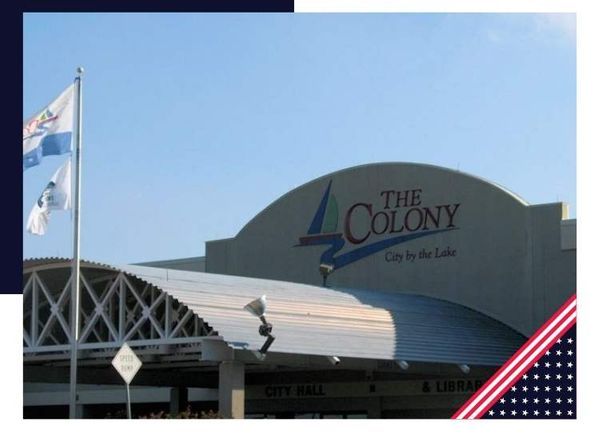 The Colony City Hall building with a blue sky and flags.