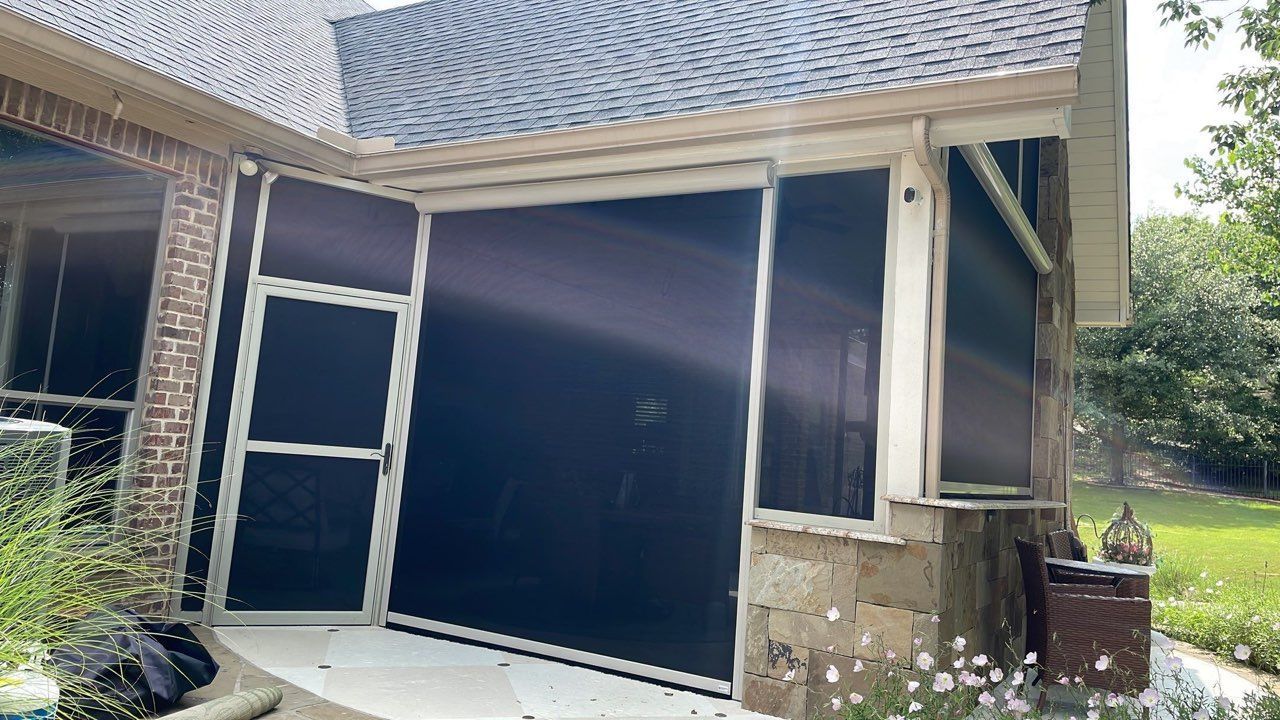 Screened-in porch with dark mesh, concrete foundation, tan trim, and a shingle roof.