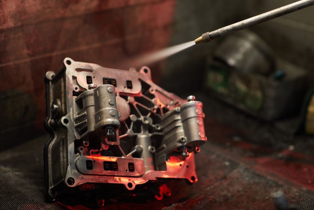 An engine being sprayed by a high pressure washer — JNL Crankshaft Services in Palmerston City, NT