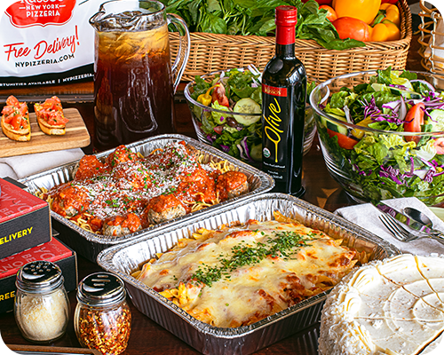 Italian food spread with pasta, meatballs, salad, cake, and iced tea.