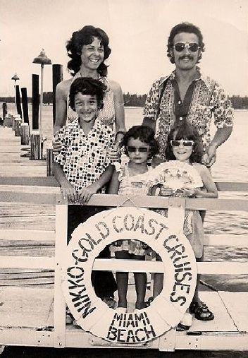 Family posing on a dock with a life preserver that reads 