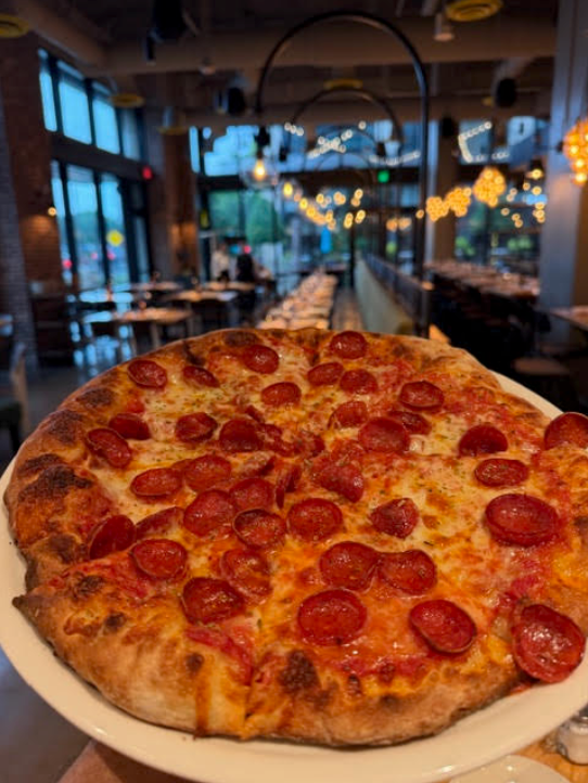 Pepperoni pizza on a plate in a cozy restaurant setting at Russo's New York Pizzeria