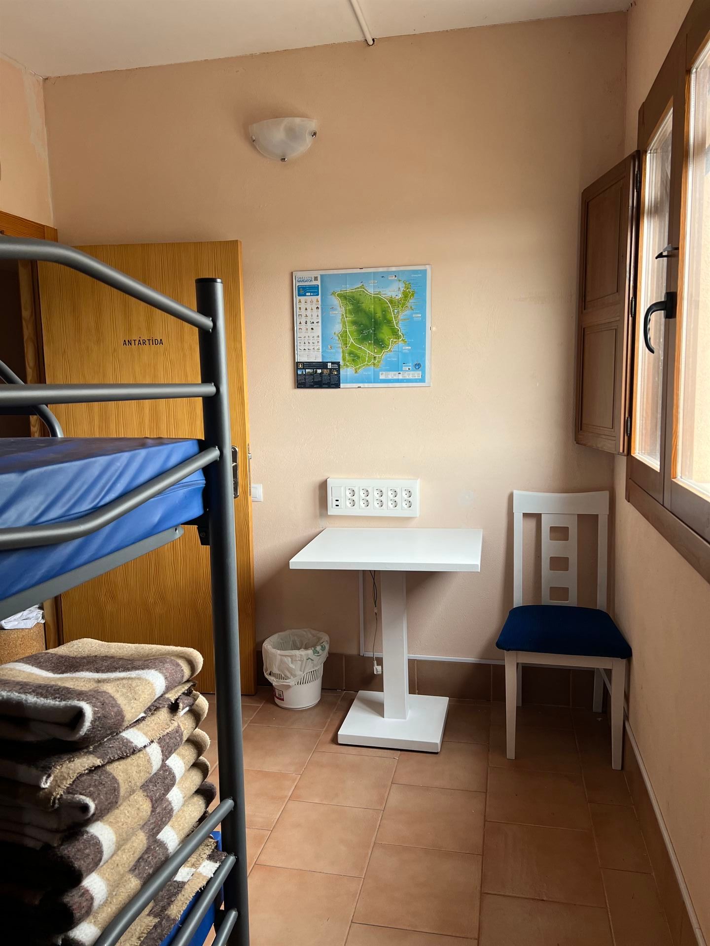 Hay una litera y una mesa en la habitación.