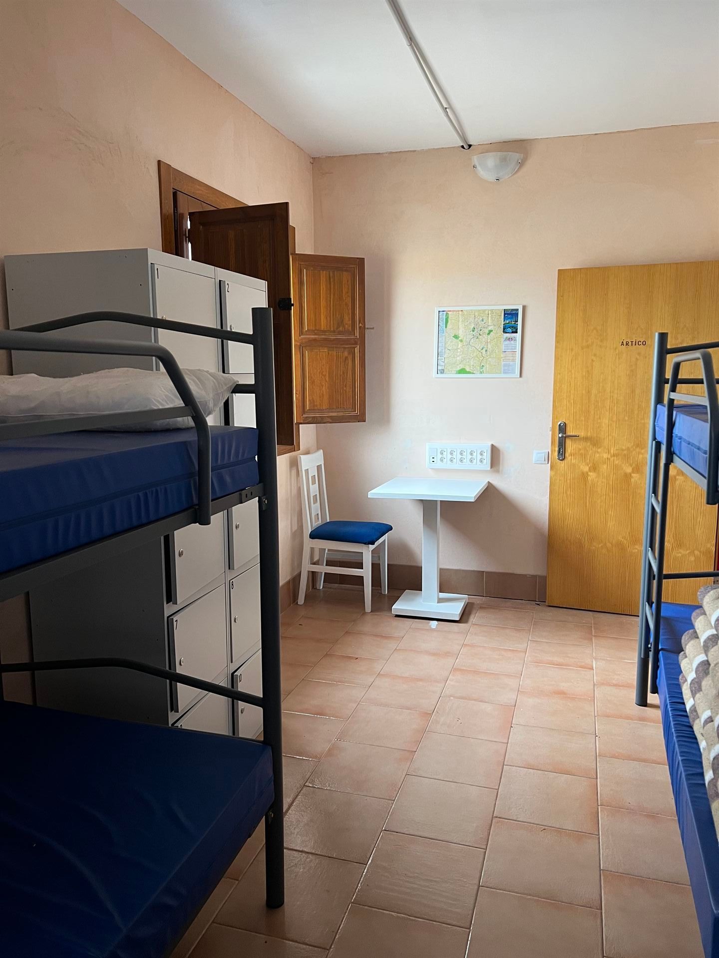 Una habitación con literas y una mesa dentro.