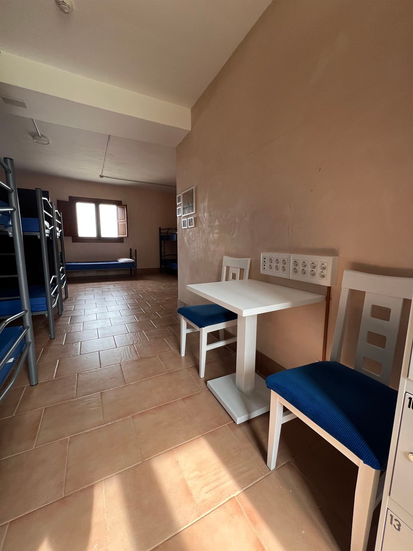 Una habitación con literas y una mesa y sillas.