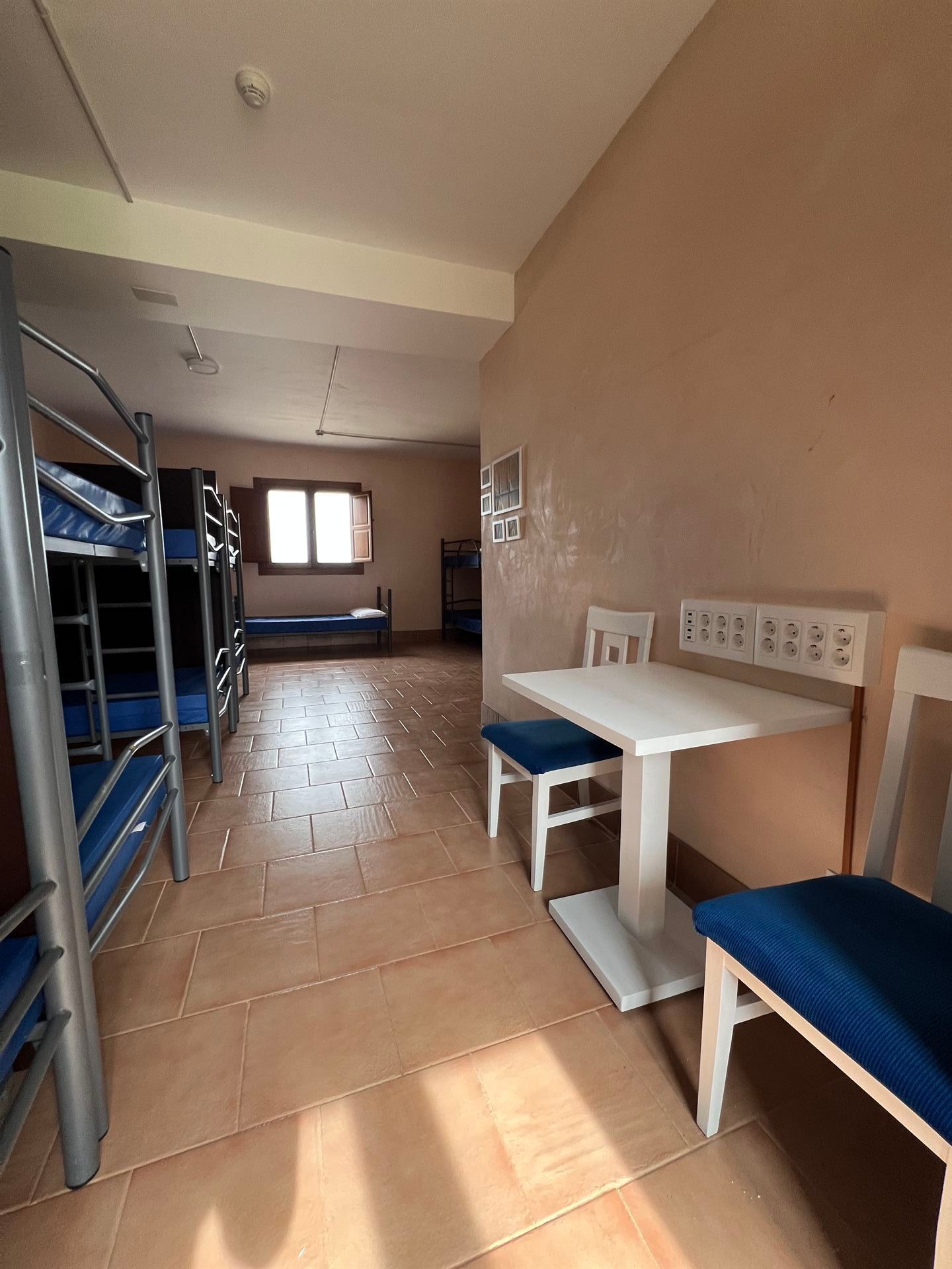 Una habitación con literas y una mesa y sillas.
